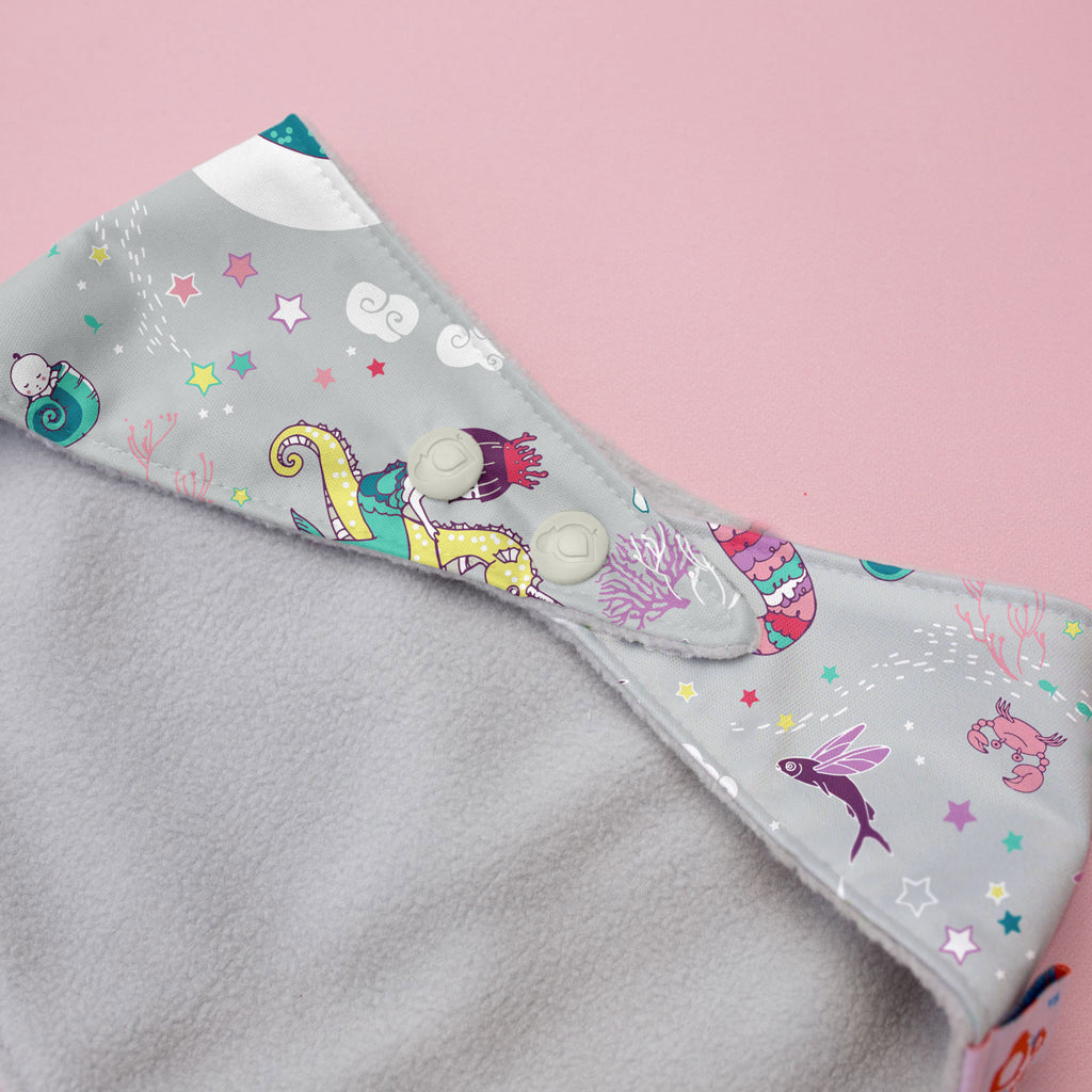Gray fabric with colorful mermaid pattern on a pink background