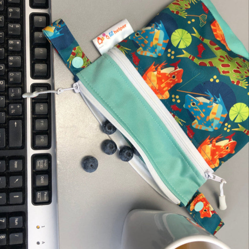 Colorful bag with animal design on a desk next to a keyboard and mug.