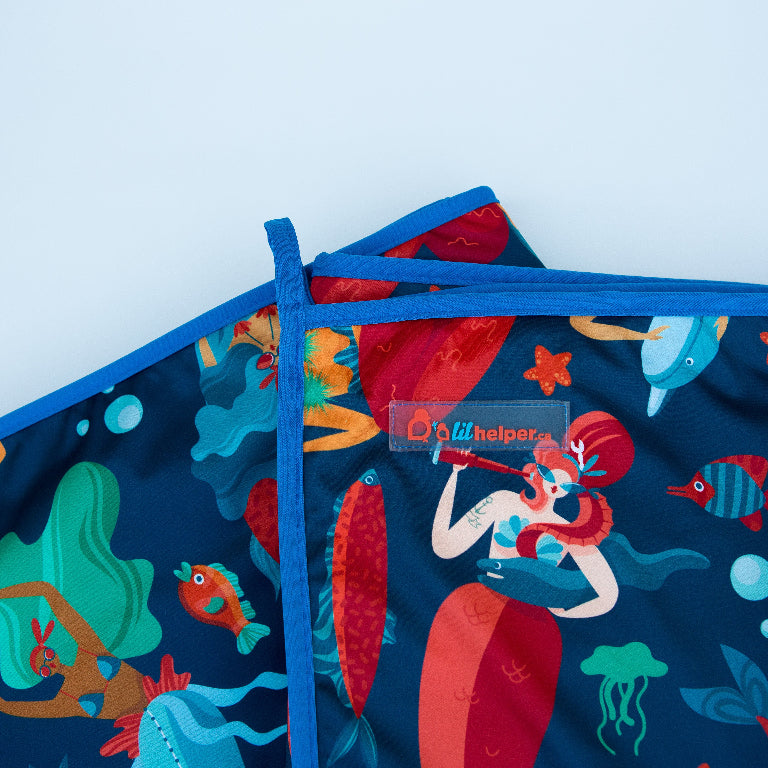 Colorful fabric featuring a whimsical underwater scene with mermaids and sea creatures.